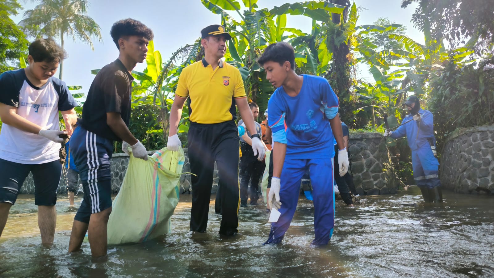 Kapolresta Bogor Kota Kombes Polisi Bismo Teguh Prakoso bersama beberapa pelajar tengah membersihkan anak sungai Ciliwung sebagai sumber irigasi sawah-sawah di Kelurahan Katulampa, Kecamatan Bogor Timur pada Sabtu 8 Juni 2024.